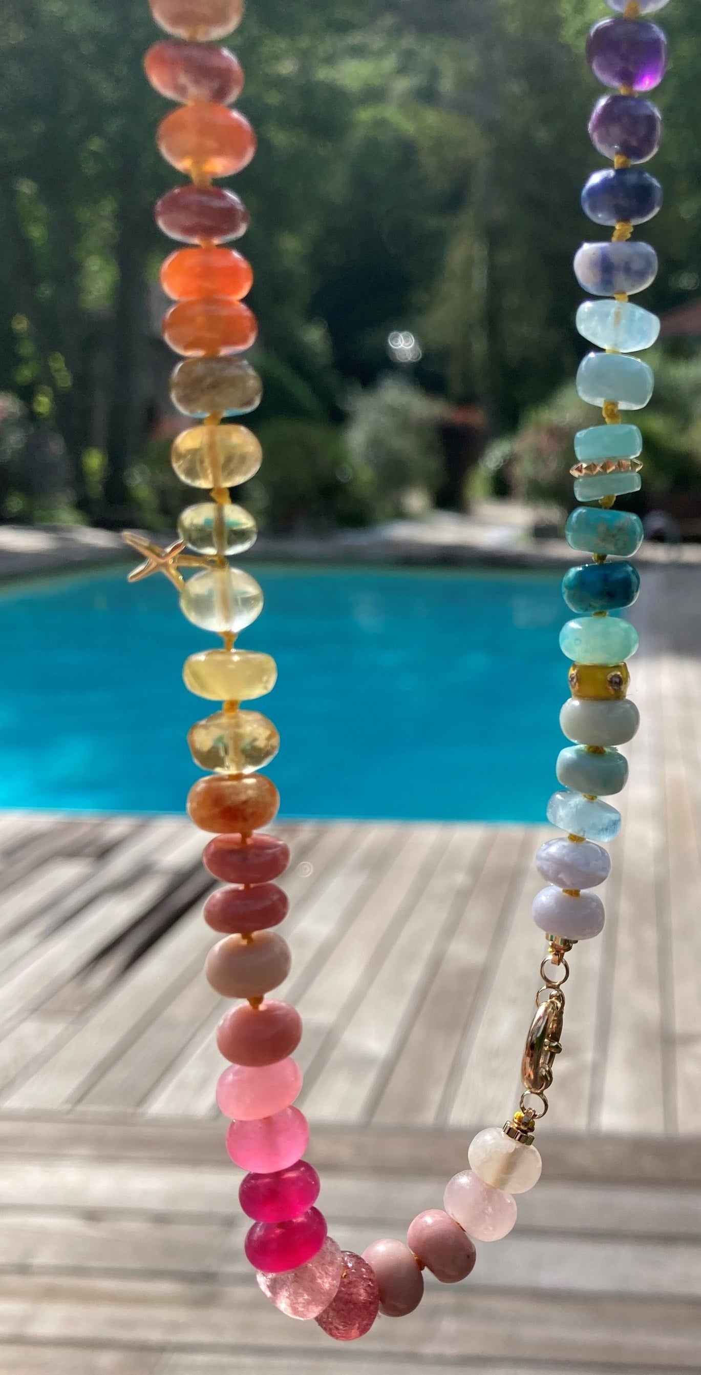 rainbow gemstone necklace near pool