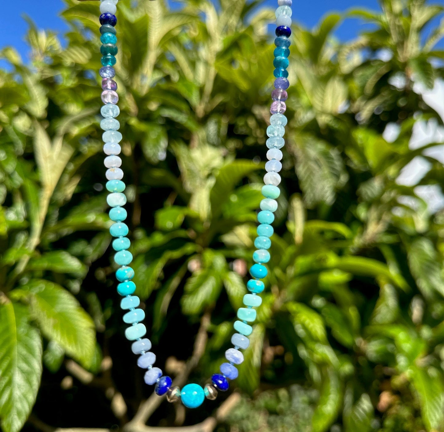 Beaded blue opal necklace near palmtrees